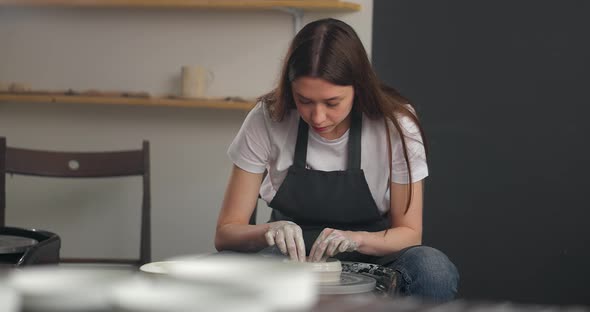 Young Woman in Pottery Studio Using Pottery Whee