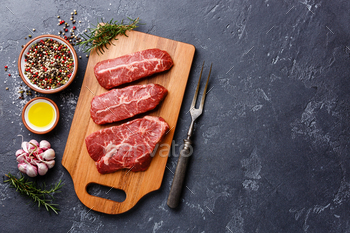 Raw fresh meat Top Blade steaks on wood cutting board on dark background / Photodune, Misc