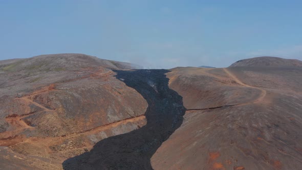 Aerial Drone Flying Forward to Fagradalsfjall Black Lava River Iceland Sunny Day