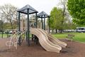 Children playground in public park surrounded by green trees - PhotoDune Item for Sale
