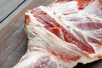 Raw beef leg on brown wooden board / Photodune, Misc