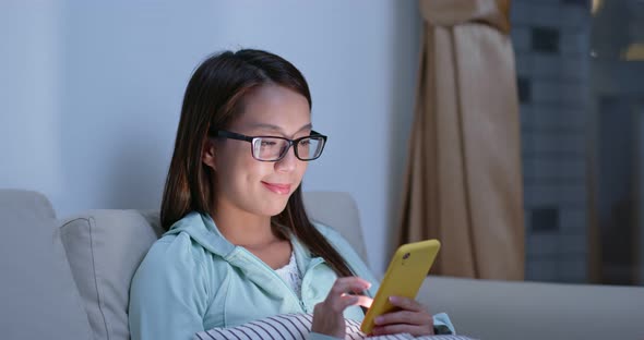 Woman with glasses and use of mobile phone at home