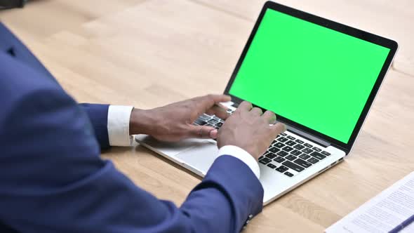 African Man Working on Laptop with Chroma Screen