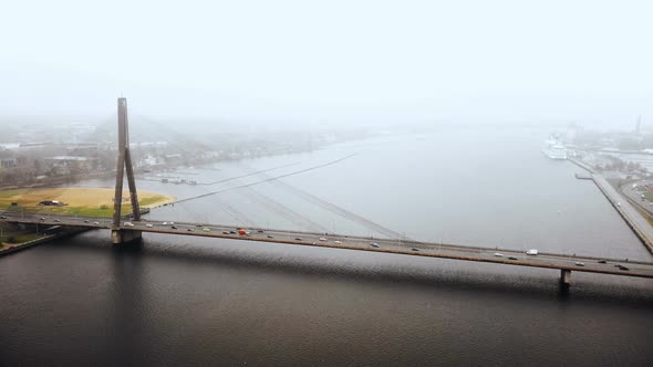 Drone Flying Towards Beautiful Old Cable Bridge Full of Car Traffic Over Epic Daugava in Riga