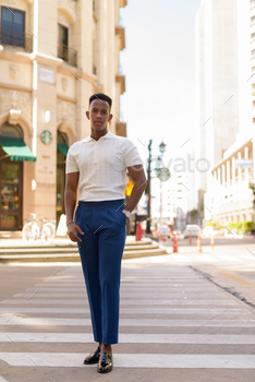 Full length shot of young African businessman outdoors walking over crosswalk / Photodune, Misc