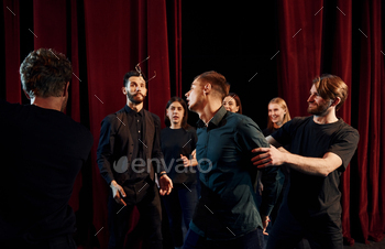 Working together. Group of actors in dark colored clothes on rehearsal in the theater / Photodune, Misc