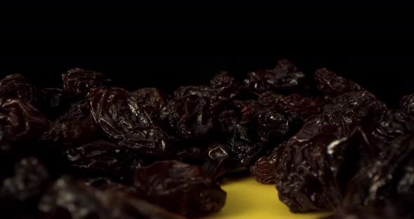 A Dry Grapes Macro Shot Closeup Shot of Ripe Raisins Lies on a Table Against a Black Background