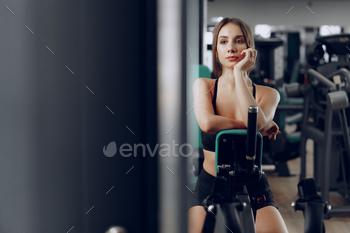Young beautiful woman training her arms in a gym apparatus / Photodune, Misc