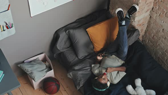 Boy Using Smartphone in his Room