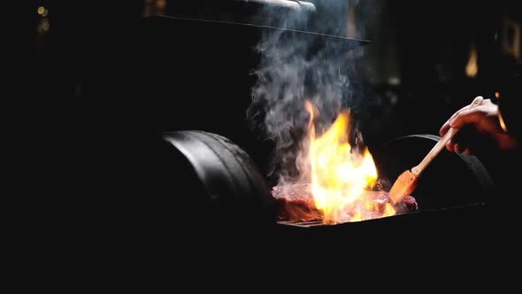 Night barbecue in backyard of house. cooking delicious steak on an open fire.