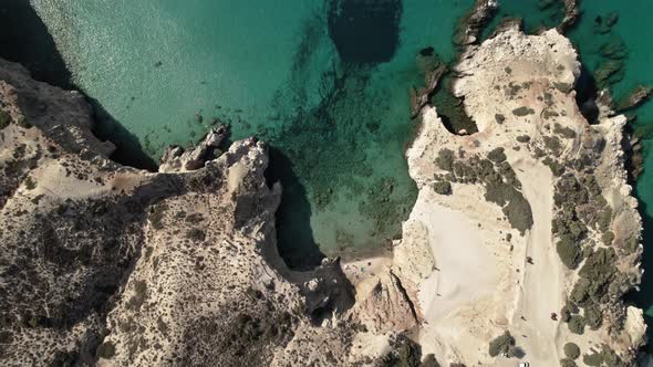 Private beach cove surrounded by white rocky cliffs on the Mediterranean. Summertime Milos Greece 4k