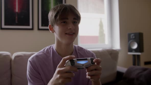 Beautiful Excited Young Gamer Man Sitting on a Couch Playing and Winning in Video Games on a Console