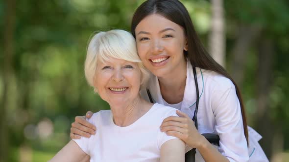 Kind Doctor Hugging and Supporting Disabled Mature Patient Caring Clinic Staff