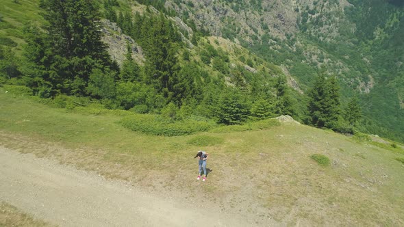 Young Couple Hugs and Kiss Each Other on Summit with Deep Valley Below