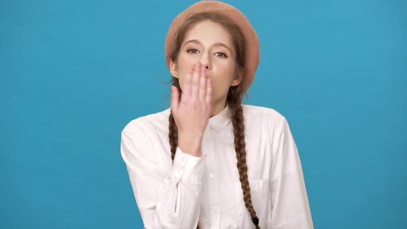 Portrait of Attractive Romantic Woman Isolated Over Blue Background Wall Giving Air Kiss on Camera