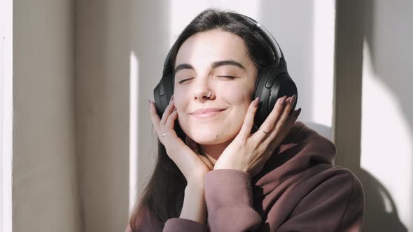 Young Woman in Headphones Listening to Music at Home