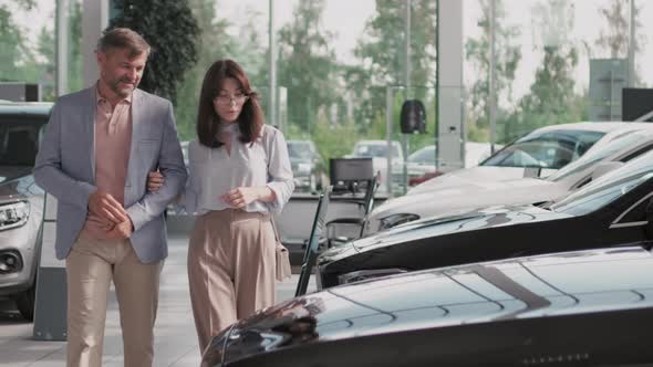 Couple Choosing Car in Dealership