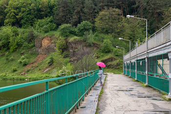 A girl under an umbrella on a bridge in the forest. / Photodune, Misc