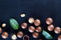 Australian macadamia nuts and green leaves on black background - PhotoDune Item for Sale