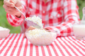 Girl in plaid shirt picks up curd or cheese from glass bowl with spoon - PhotoDune Item for Sale