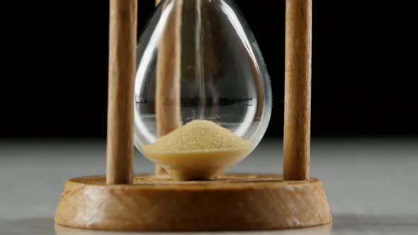 Bottom Portion of an Hourglass with a Sand. Black. Close Up