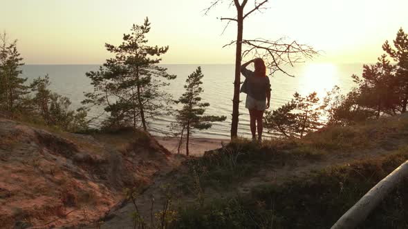 Drone Flight From Backside To Sea Horizon: Young Woman Enjoys Beautiful Scenic Sunset at Baltic Sea