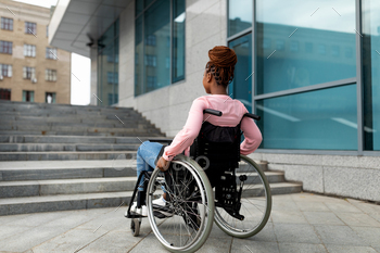 Young black impaired lady in wheelchair cannot go up stairs without ramp, feeling limited and / Photodune, Misc