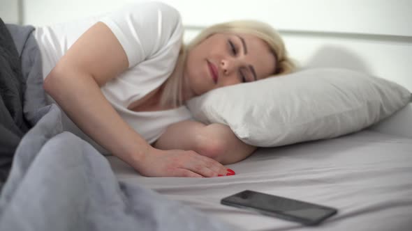 Happy Woman Using Smartphone on the Bed at Home