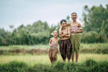 Siam kids in Thai traditional dress standing in rice field / Photodune, Misc