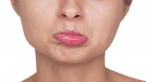 Macro View of Adult Woman with Healthy Clean Skin and Natural Makeup Twisting Her Lips Being Upset