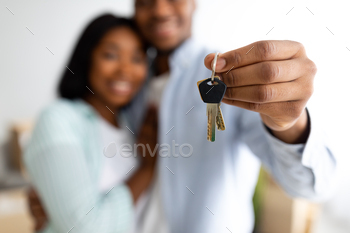 New home owners. Happy african american couple holding home keys, celebrating buying new flat / Photodune, Misc