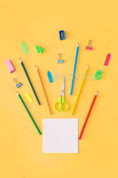 White sticker with school supplies pointing upwards on yellow background / Photodune, Misc