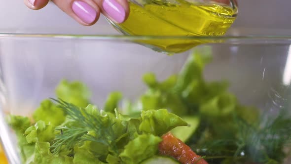 Female Cook Pouring Olive Oil in Fresh Vegetable Salad Seasoning It, Slow-Mo