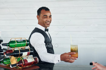 With order in hand. Black waiter in formal clothes is at his work outdoors at sunny daytime / Photodune, Misc