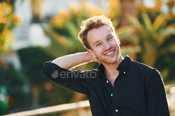 Young man is outdoors at sunny daytime. Concept of vacation / Photodune, Misc