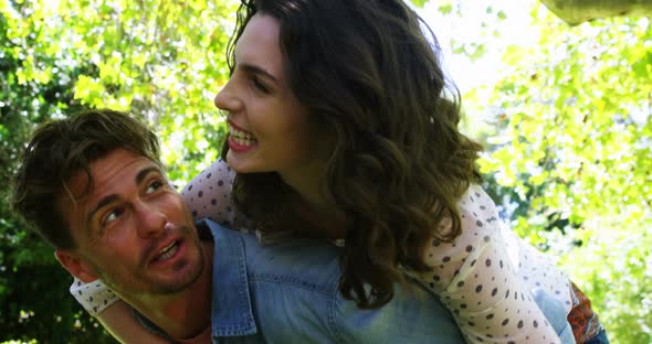 Man giving piggyback to woman in park