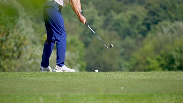 Super slow motion of fashionable golfer hitting ball on golf course in sun - Low angle medium shot