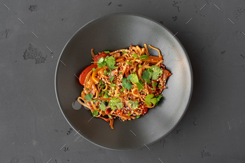 Top view of wok noodles with vegetables and meat in bowl on gray background / Photodune, Misc
