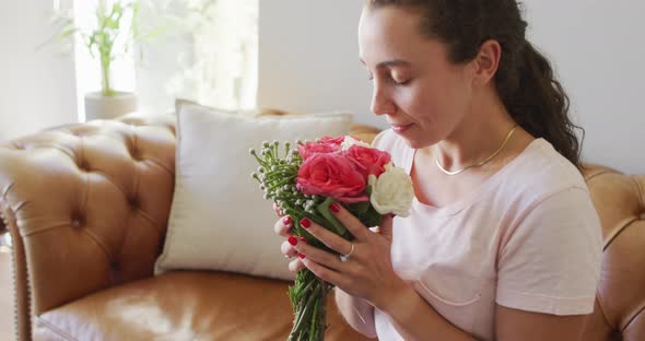 Happy young caucasian woman in love smelling a bouquet of flowers