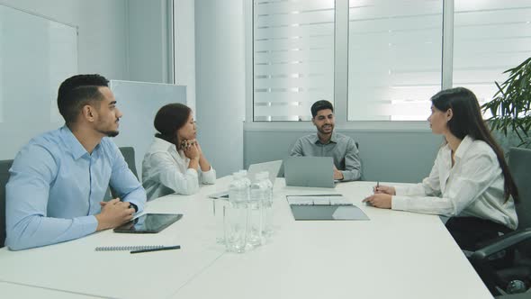 Indian Businessman Talking to Business People Colleagues or Partners Sitting at Conference Table