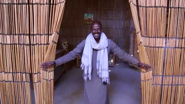 Local man opening curtain made of sugar cane