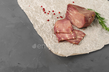 Meat sausage on parchment on gray background / Photodune, Misc
