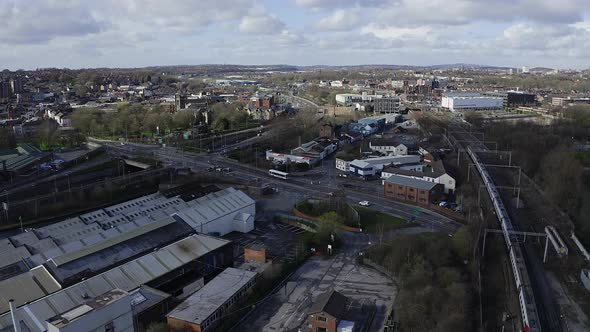 Aerial footage of trains approaching Stoke on Trent train station in the midlands by the canal, wate