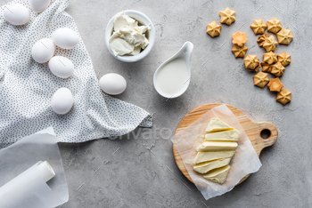 flat lay with cut butter, sour cream, cookies and raw chicken eggs ingredients for making pie on / Photodune, Misc
