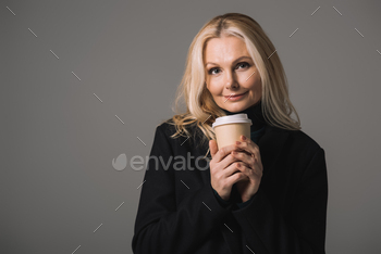 happy mature woman with disposable cup of coffee isolated on grey / Photodune, Misc