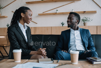 portrait of smiling african american business partners looking at each other in cafe / Photodune, Misc