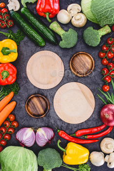 top view of empty wooden plates and fresh raw organic vegetables on black / Photodune, Misc