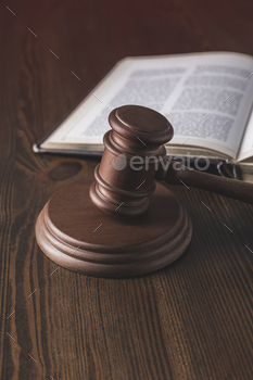 opened juridical book with hammer on wooden table, law concept / Photodune, Misc