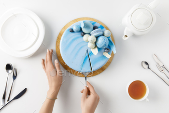 top view of cropped hands slicing cake on chopping board isolated on white / Photodune, Misc