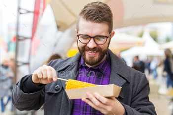 Man eating grilled corn. vegetarian food. healthy and tasty vegetables / Photodune, Misc